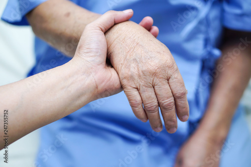 Fototapeta Naklejka Na Ścianę i Meble -  Holding Touching hands Asian senior or elderly old lady woman patient with love, care, helping, encourage and empathy at nursing hospital ward : healthy strong medical concept 