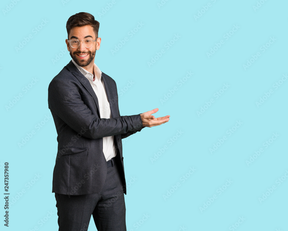 Young handsome business man holding something with hands Young handsome business man holding something with hands