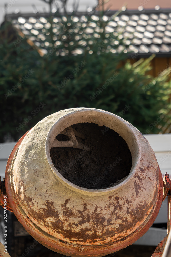 Construction site work with concrete mixer and wheelbarrows