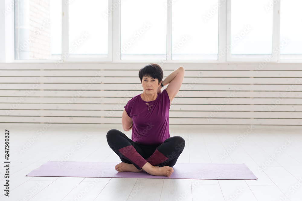 Yoga, people concept - a middle-aged woman doing a yoga in the gym Yoga, people concept - a middle-aged woman doing a yoga in the gym