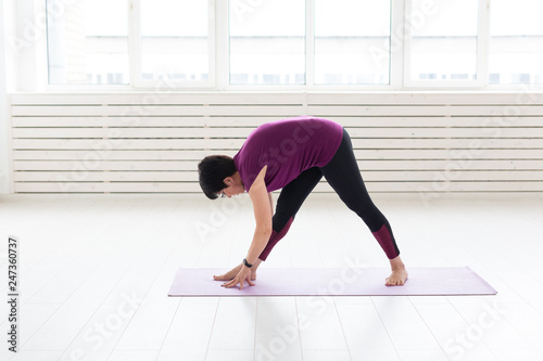 Yoga, people concept - a middle-aged woman doing a yoga and try to do a asana