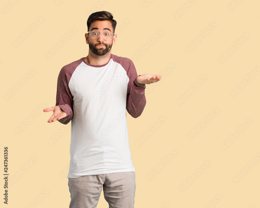 Young handsome man confused and doubtful Young handsome man confused and doubtful