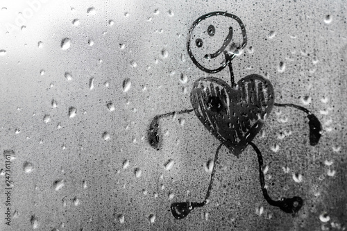 Human figure with a heart on a misted window