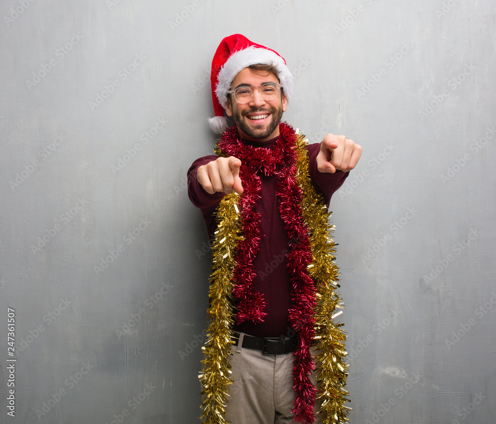 Young man celebrating christmas day holding gifts cheerful and smiling
