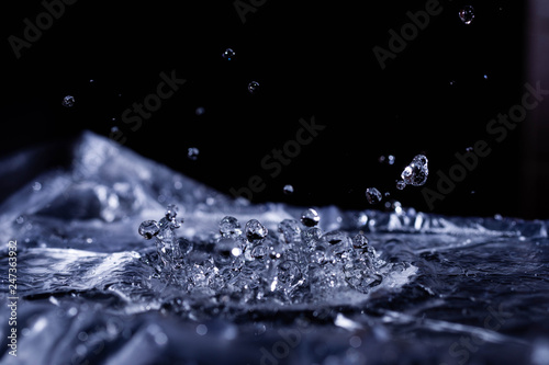 Water drops splashing on acoustic membrane. A lot of drops in air. High frequency of sound waves. Water cloud small drops. Frozen time shot.