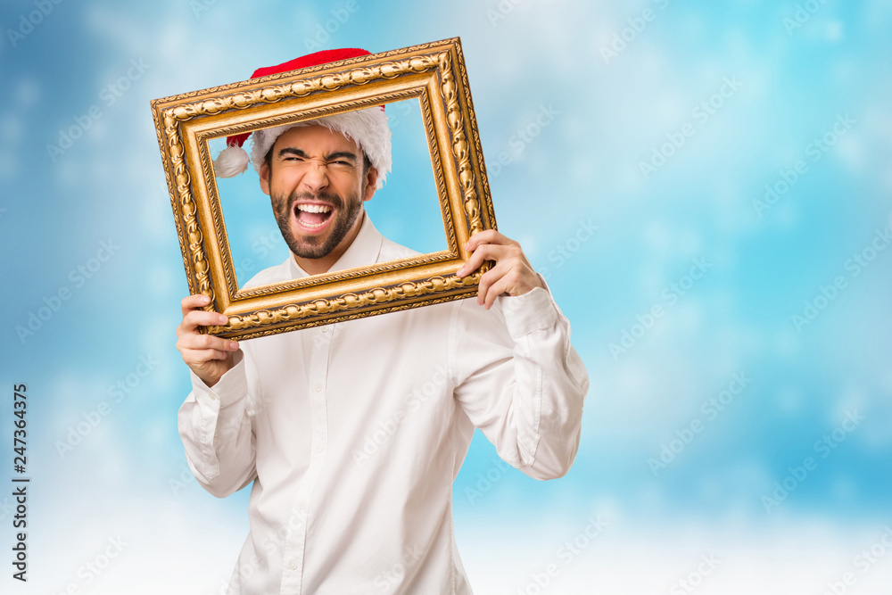 Fototapeta premium Young man wearing a santa claus hat on Christmas day