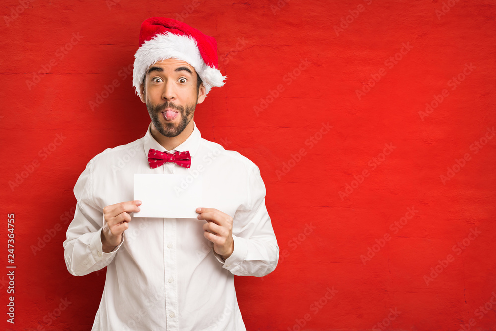 Young man wearing a santa claus hat on Christmas day Young man wearing a santa claus hat on Christmas day