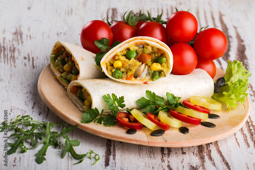 Burritos with vegetables  on a wooden plate