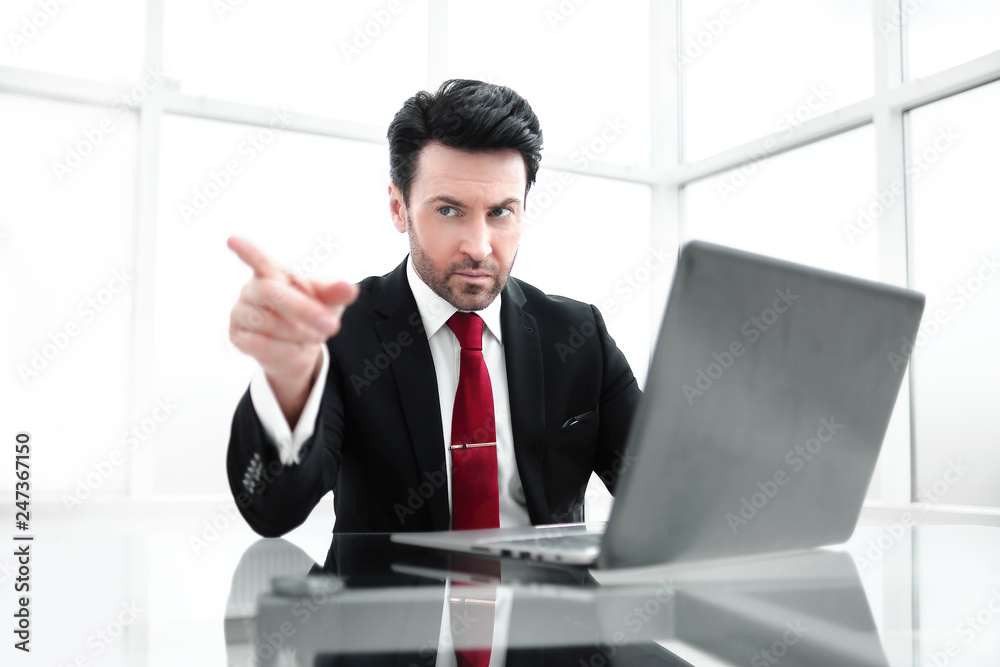 Businessman pointing the finger at you,sitting at his Desk Businessman pointing the finger at you,sitting at his Desk