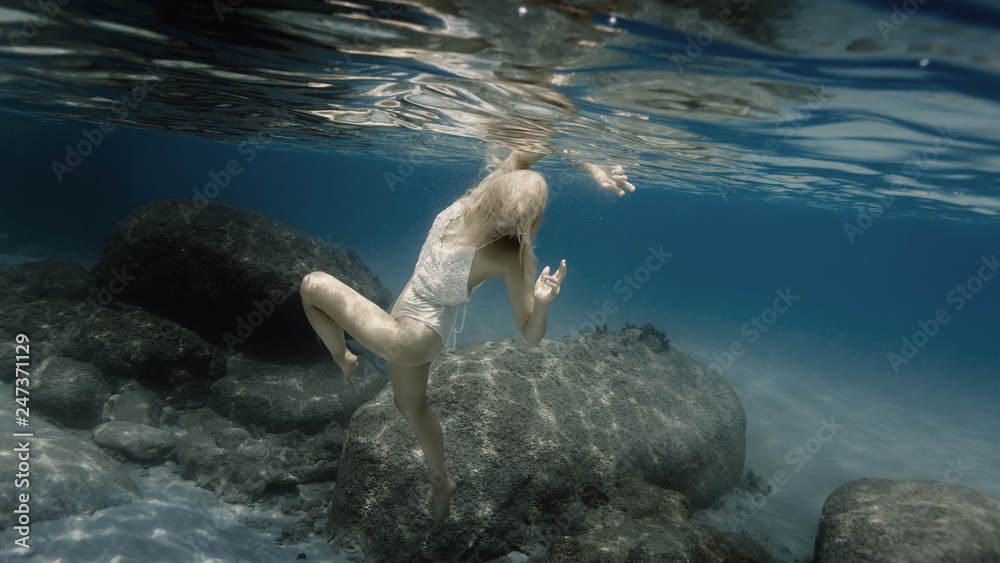 Obraz premium Woman in white under water in the sea