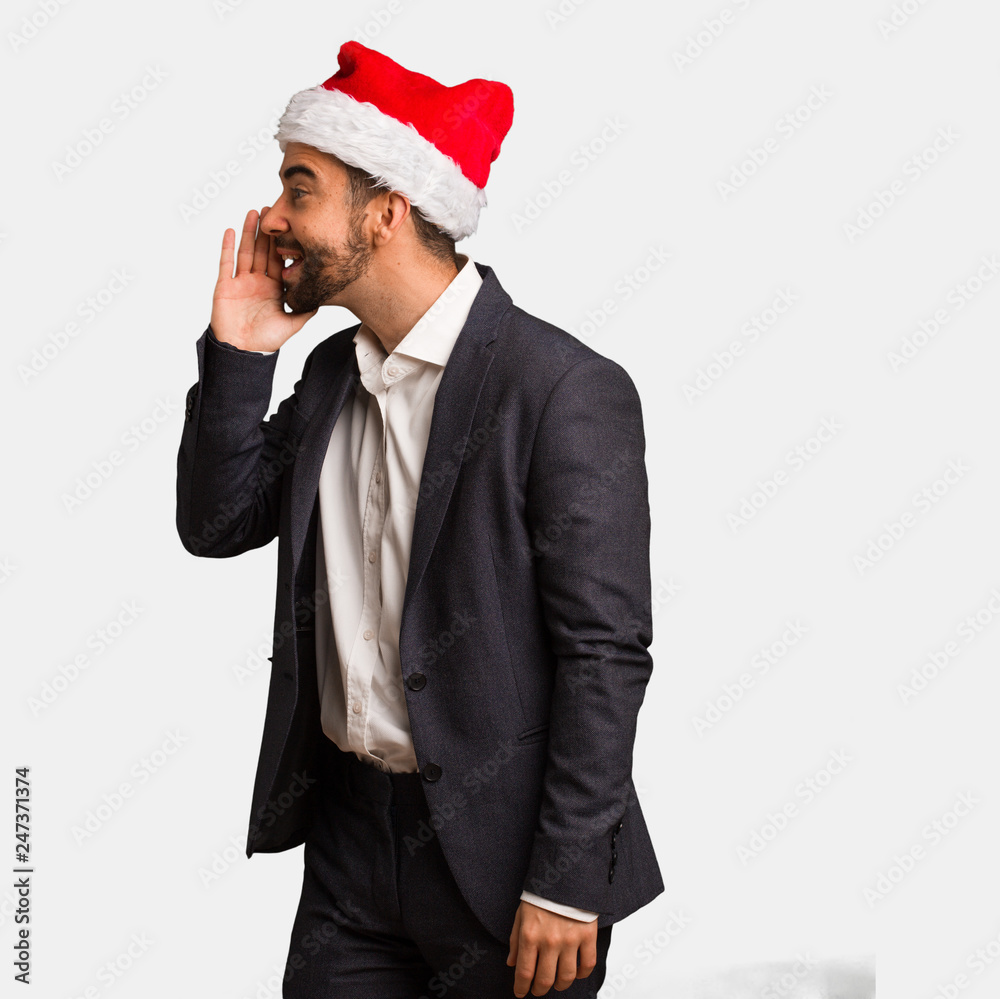 Young business man wearing santa hat whispering gossip undertone Young business man wearing santa hat whispering gossip undertone