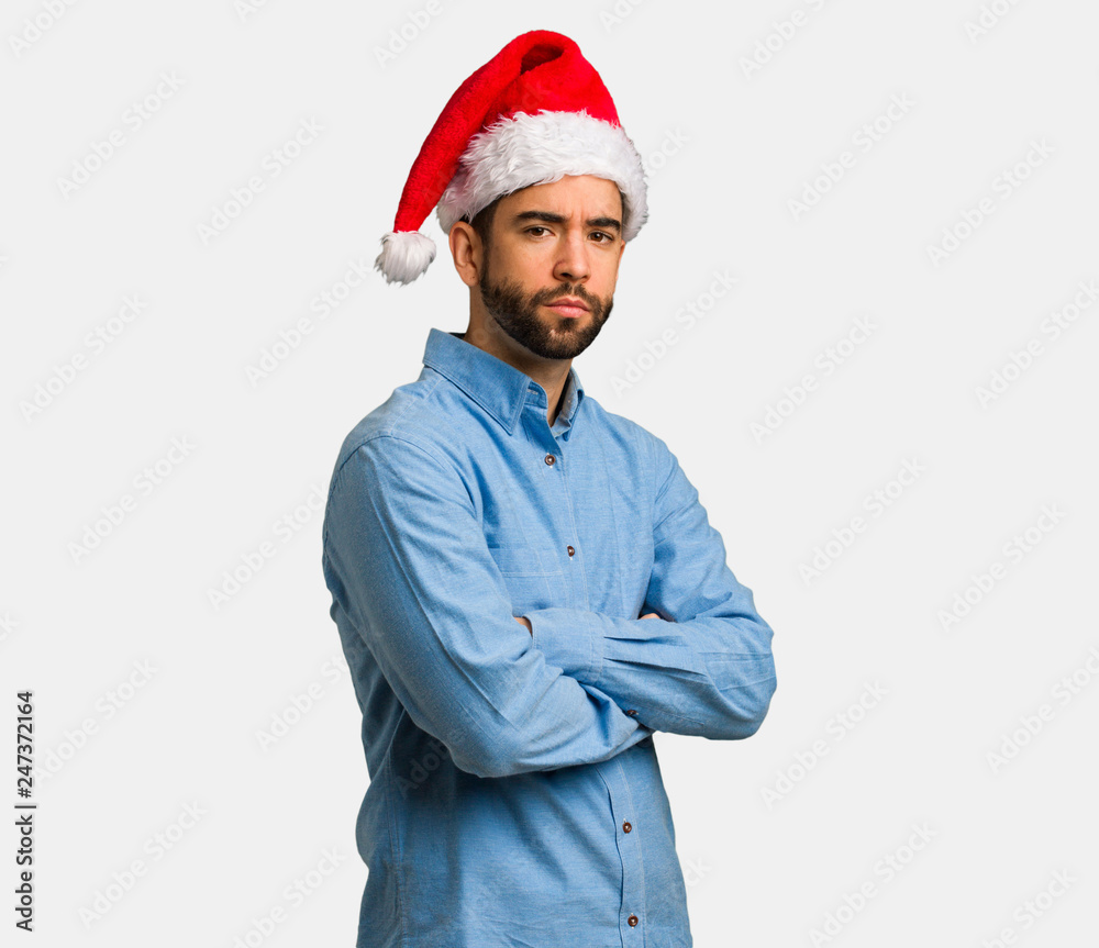Young man wearing santa hat looking straight ahead Young man wearing santa hat looking straight ahead
