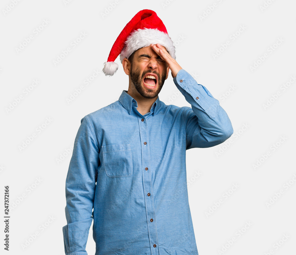 Young man wearing santa hat forgetful, realize something Young man wearing santa hat forgetful, realize something