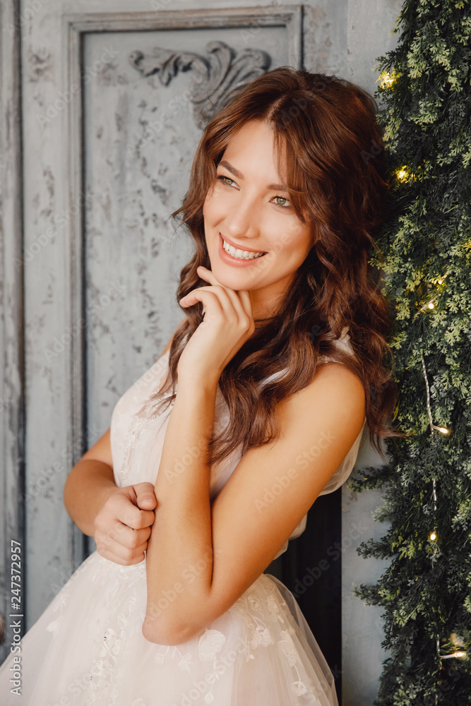 Fototapeta premium Portrait of beautiful young woman in white wedding dress smiling