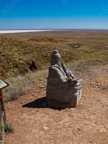 The figure of the Buddhist deity - the White Elder - at the ascent of the mountain Big Bogdo. Buddhists consider it a holy mountain; it is a sacred place for Kalmyks. Lake Baskunchak in the distance photo