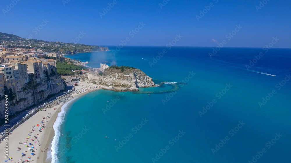 Tropea skyline and coastline with beach umbrellas, Italy. Aerial view on a beautiful sunny morning