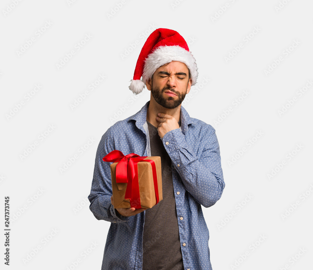 Young man wearing santa hat coughing, sick due a virus or infection Young man wearing santa hat coughing, sick due a virus or infection