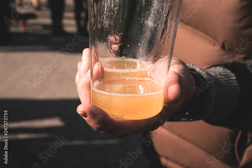 young man hand offering a glass of fresh cider in the north of Spain photo