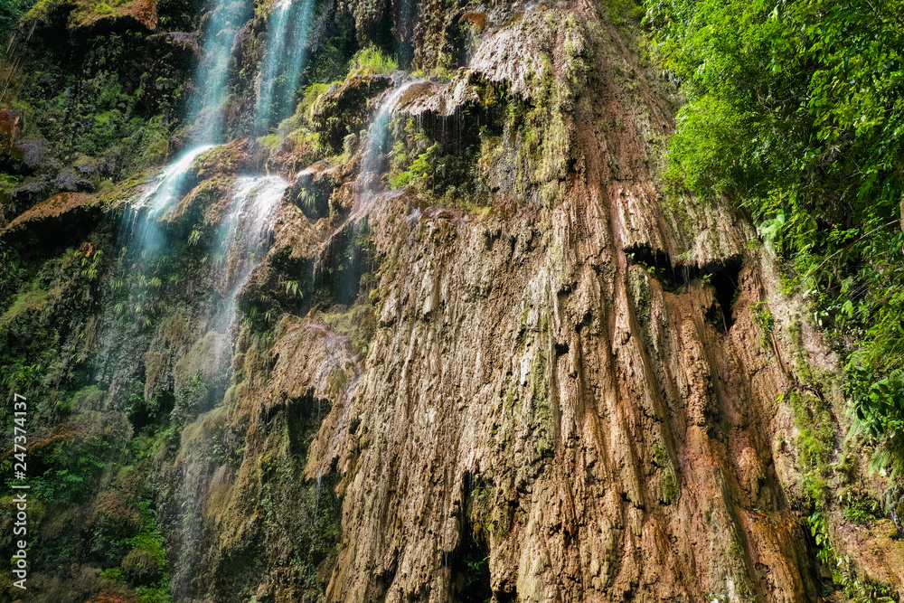 Tumalog waterfall in a mountain gorge in the tropical jungle of the Philippines, Cebu.