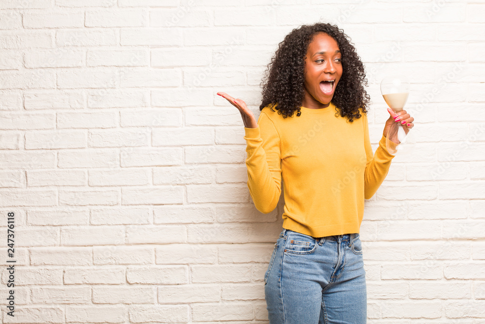 Young black woman screaming happy, surprised by an offer or a promotion, gaping, jumping and proud Young black woman screaming happy, surprised by an offer or a promotion, gaping, jumping and proud