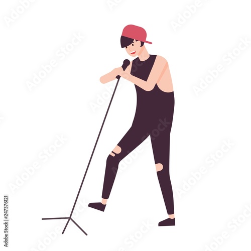 Happy man singer, rock vocalist or punk rocker wearing cap and singing in microphone