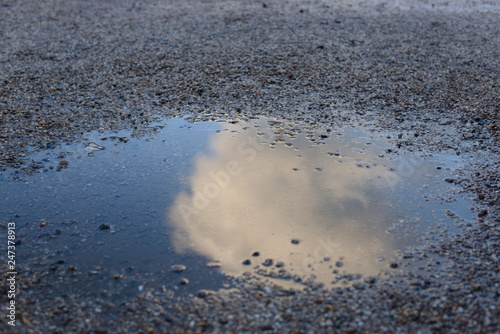 Photo Cloud in puddle reflection gravel