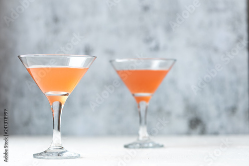 Cocktails in a martini glass on a gray background.