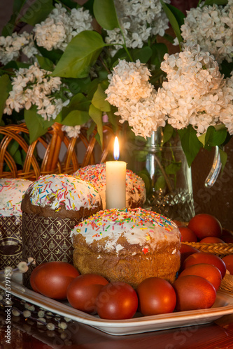 Easter composition with a traditional Russian Easter cake, Easter eggs and flowers on the table