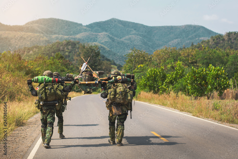Obraz premium The transport of wounded soldiers to heal.Soldiers are carrying their wounded soldiers on the battlefield to safe places for medical treatment