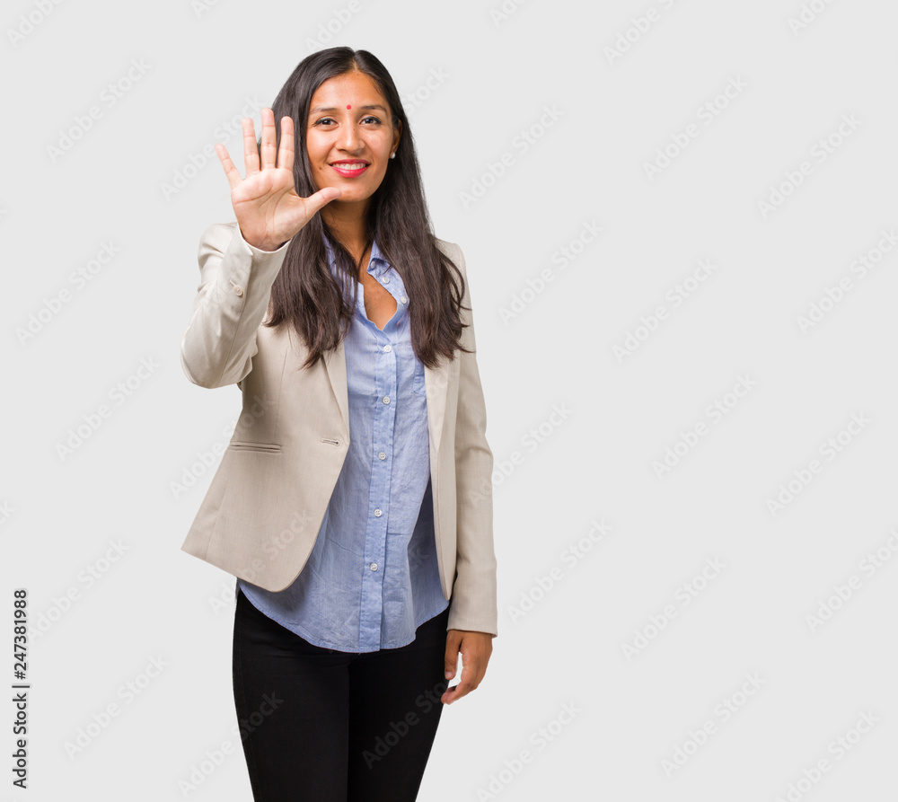 Young business indian woman showing number five, symbol of counting, concept of mathematics, confident and cheerful Young business indian woman showing number five, symbol of counting, concept of mathematics, confident and cheerful