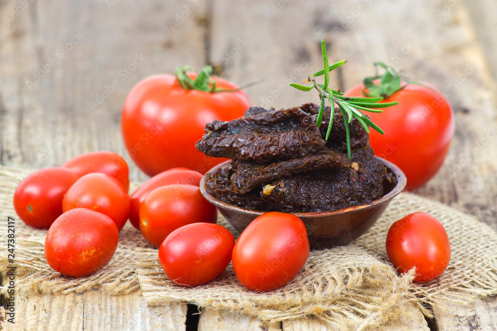 fresh and dried tomatoes on wooden background fresh and dried tomatoes on wooden background