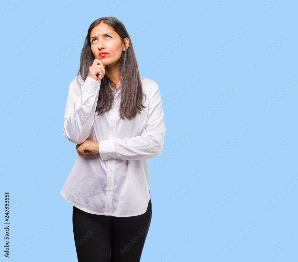 Portrait of a young indian woman doubting and confused, thinking of an idea or worried about something Portrait of a young indian woman doubting and confused, thinking of an idea or worried about something
