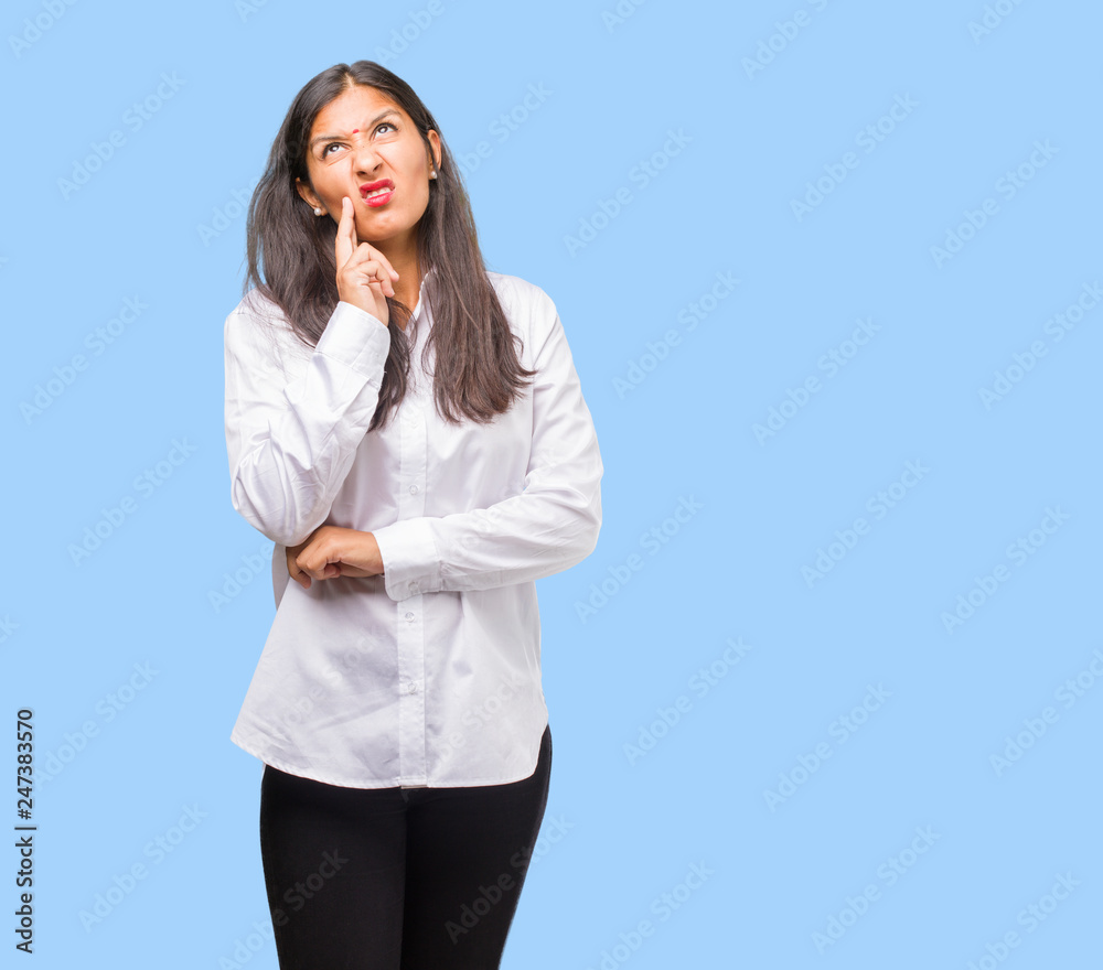 Portrait of a young indian woman doubting and confused, thinking of an idea or worried about something Portrait of a young indian woman doubting and confused, thinking of an idea or worried about something