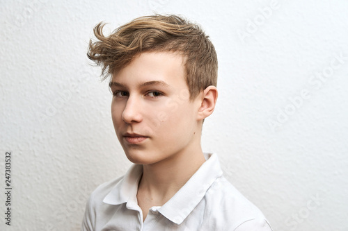 Portrait of a teenage boy blond on a white background close-up