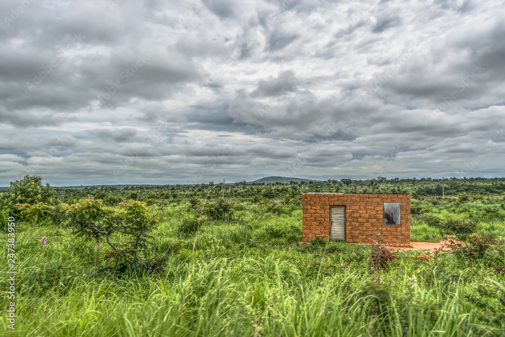 View of traditional terracotta house isolated on the middle at the tropical landscape, cloudy sky as background View of traditional terracotta house isolated on the middle at the tropical landscape, cloudy sky as background