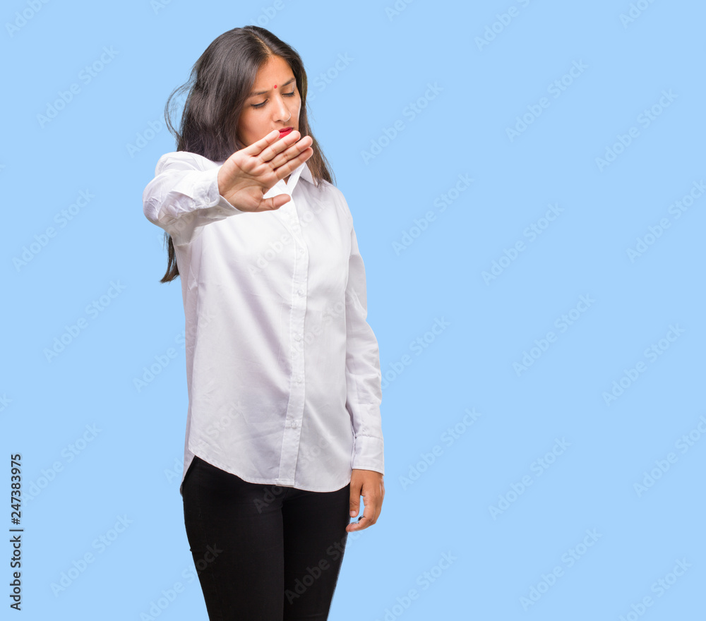 Portrait of a young indian woman serious and determined, putting hand in front, stop gesture, deny concept Portrait of a young indian woman serious and determined, putting hand in front, stop gesture, deny concept