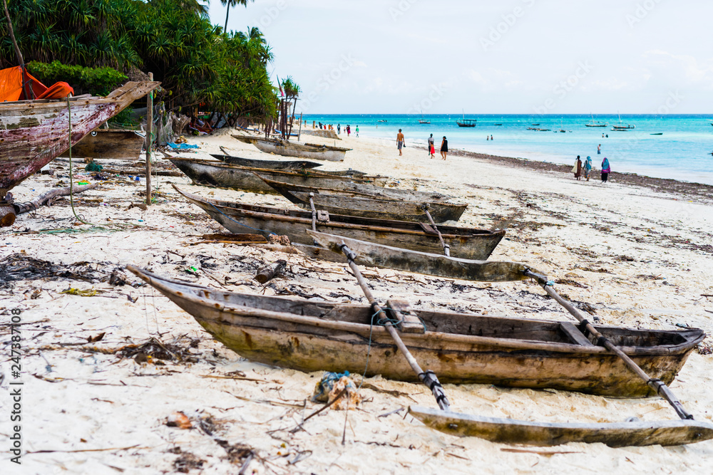 old wooden fishing boats with paddles on a beach of fishing village in Zanzibar old wooden fishing boats with paddles on a beach of fishing village in Zanzibar