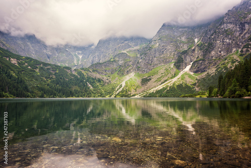 Amazing nature, alpine lake in the mountains, summer landscape with cloudy sky and reflection in crystal clear water, Morske Oko (Eye of the Sea), Tatra Mountains, Zakopane, Poland