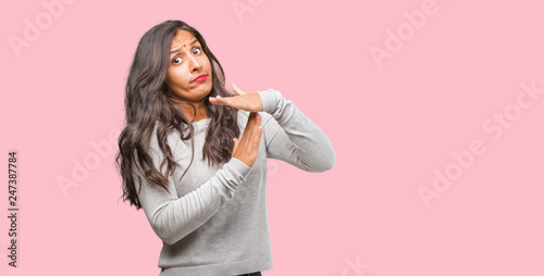 Portrait of young indian woman tired and bored, making a timeout gesture, needs to stop because of work stress, time concept