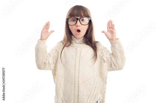 Surprised girl in glasses shows hands up, isolated on white background.