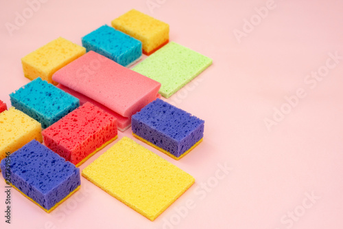 Different clean sponges isolated on pastel pink background
