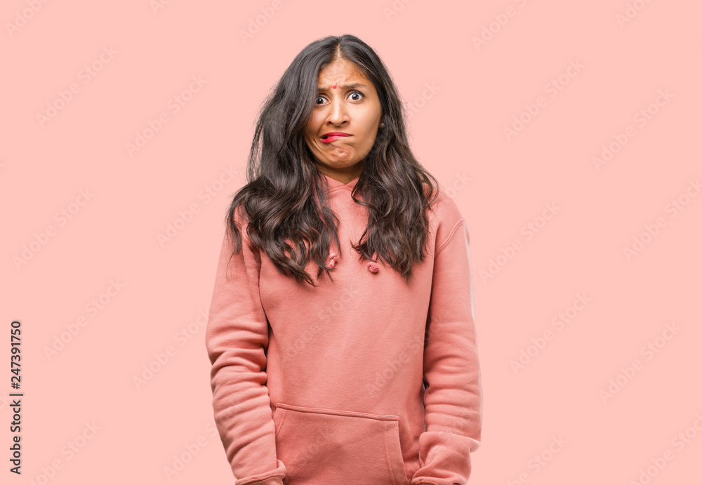 Portrait of fitness young indian woman worried and overwhelmed, forgetful, realize something, expression of shock at having made a mistake Portrait of fitness young indian woman worried and overwhelmed, forgetful, realize something, expression of shock at having made a mistake