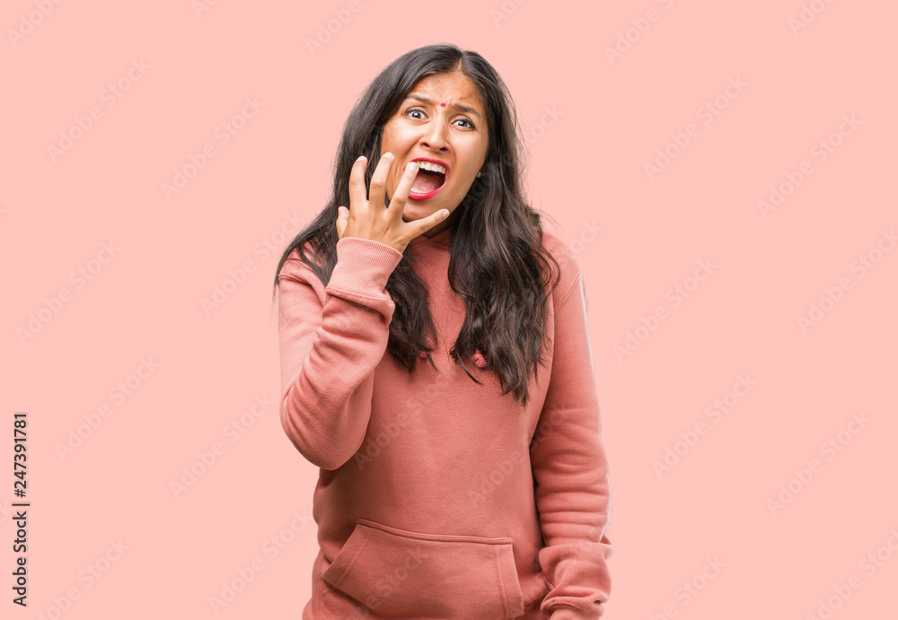 Portrait of fitness young indian woman very scared and afraid, desperate for something, cries of suffering and open eyes, concept of madness Portrait of fitness young indian woman very scared and afraid, desperate for something, cries of suffering and open eyes, concept of madness