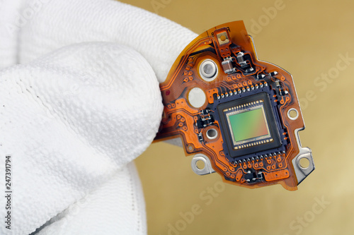 A technician controls the quality of a modern sensor for a photo camera macro