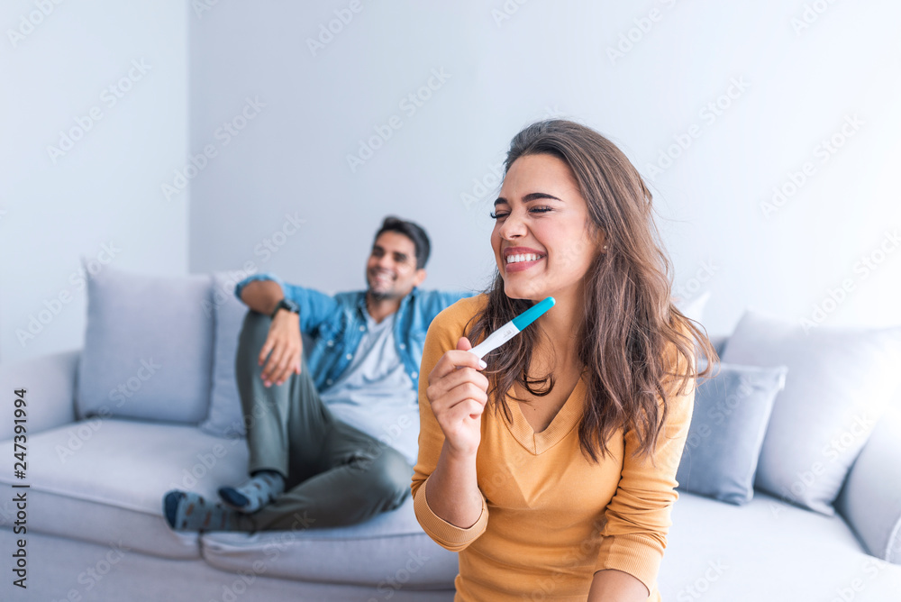 Attractive woman surprised and overjoyed reading pregnancy test. Attractive woman surprised and overjoyed reading pregnancy test.
