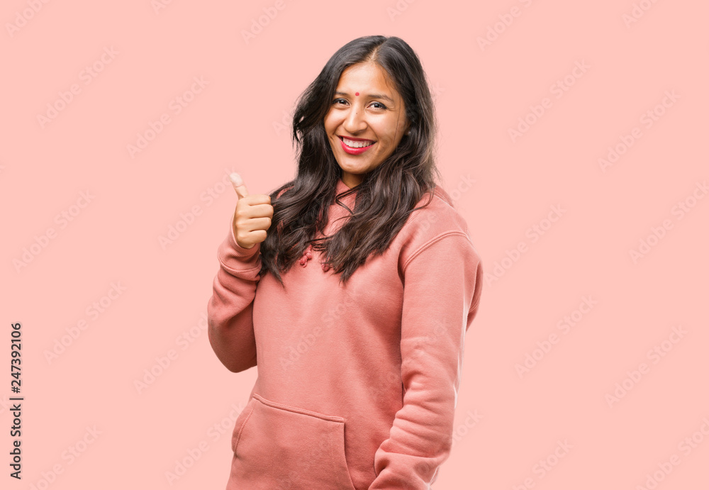 Portrait of fitness young indian woman cheerful and excited, smiling and raising her thumb up, concept of success and approval, ok gesture Portrait of fitness young indian woman cheerful and excited, smiling and raising her thumb up, concept of success and approval, ok gesture