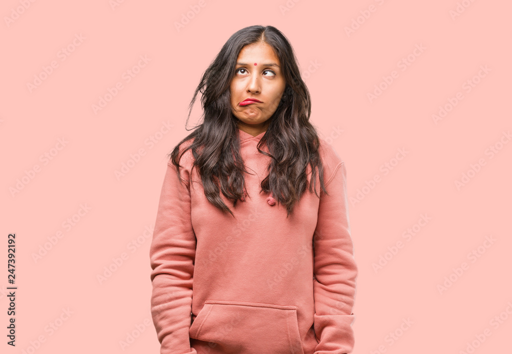 Fototapeta premium Portrait of fitness young indian woman crazy and desperate, screaming out of control, funny lunatic expressing freedom and wild