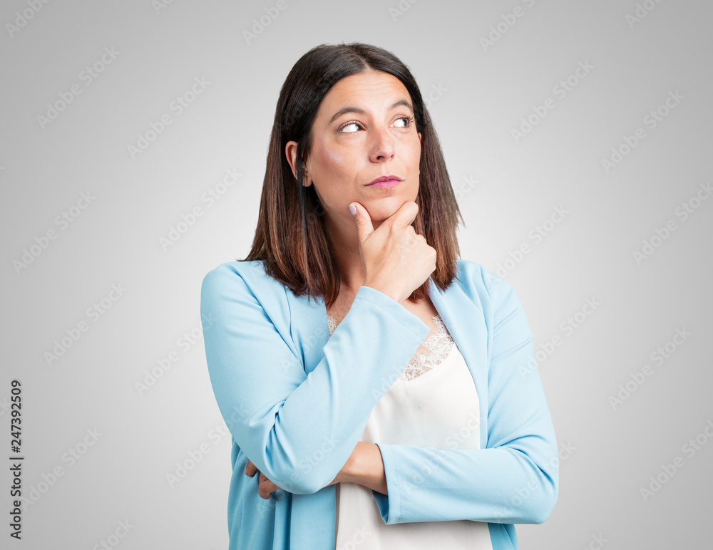 Middle aged woman doubting and confused, thinking of an idea or worried about something Middle aged woman doubting and confused, thinking of an idea or worried about something