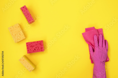 Woman hand holding cleaning towel near different sponges