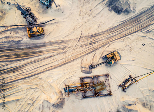 Aerial view of machinery and mine equipment near road on sandy surface photo